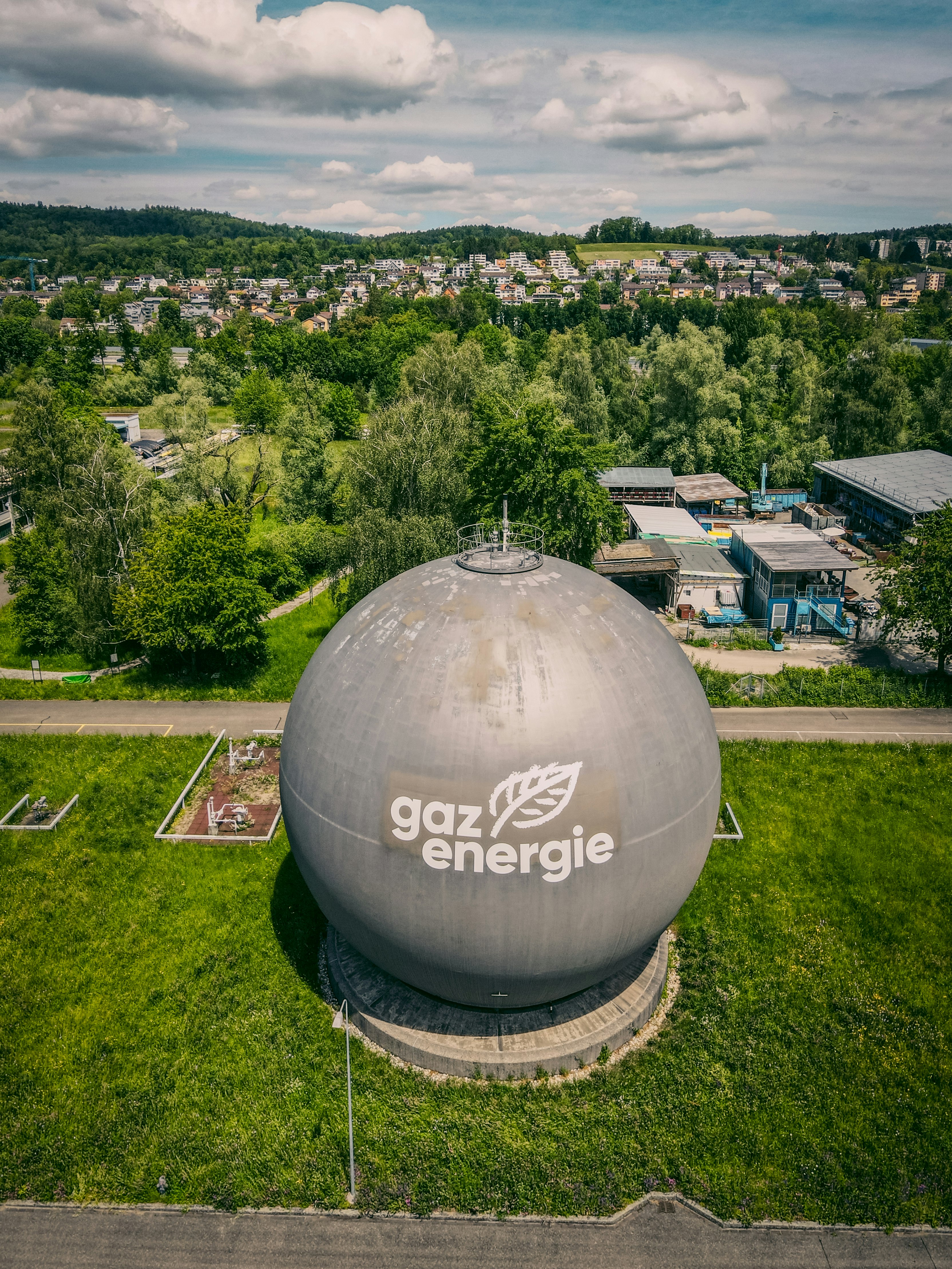 white and gray round water tank on green grass field during daytime